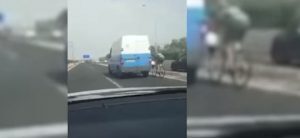 Also Nein. Ein Radfahrer, der in einem Lieferwagen gefangen ist, fährt auf einer Autobahn auf Mallorca zu 100 km / h