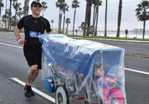 Un atleta corre una maratona spingendo i suoi 5 bambini nati prematuri