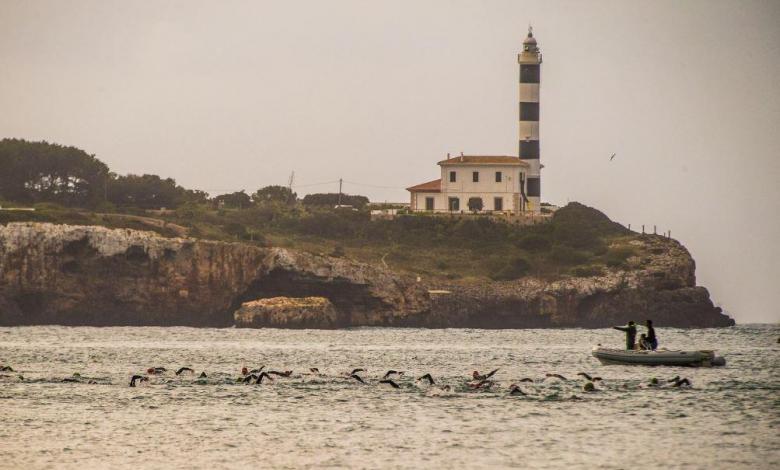 Triatlo Portocolom nadando com o farol ao fundo