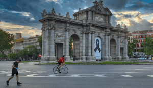 Radfahrer und Läufer an der Puerta de Ácala in Madrid
