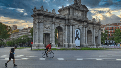 Cyclist and runner at Puerta de Ácala in Madrid