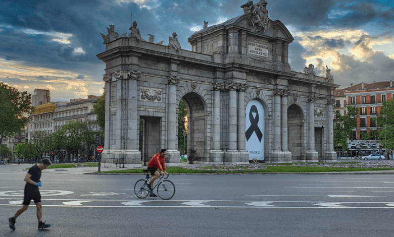 Ciclista y corredor en la Puerta de Ácala de Madrid