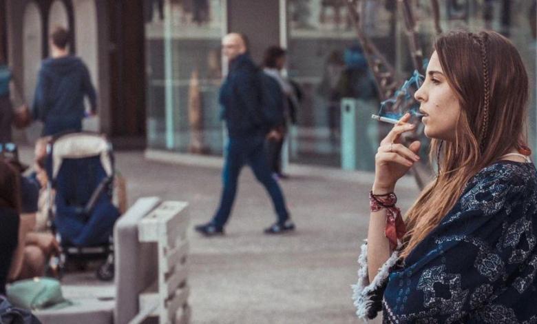 Mujer fumando en la calle