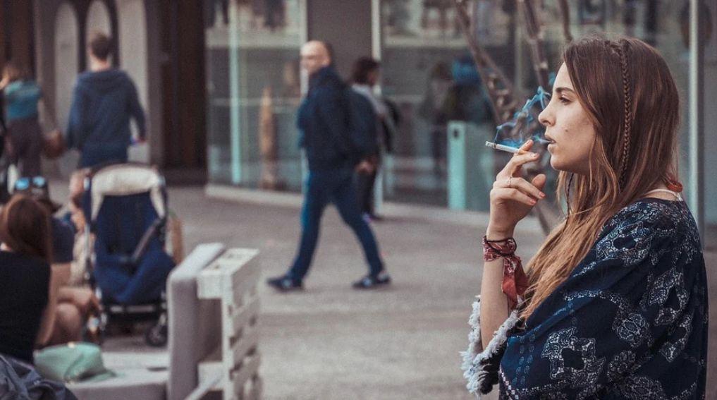 Mujer fumando en la calle