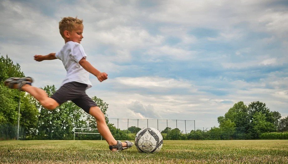 Menino jogando futebol