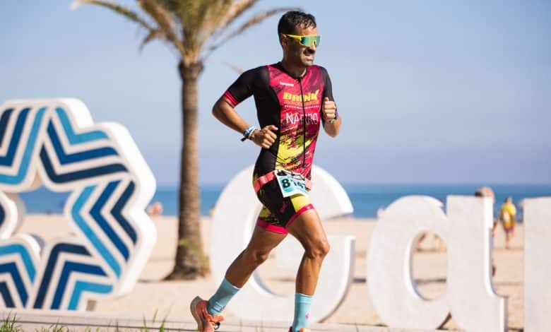 Imagem de um triatleta correndo na praia de Gandia