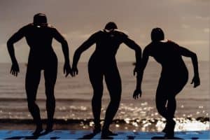 3 triathletes about to jump into the water