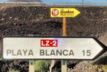 Imagen del cartel del IRONMAN 70.3 Lanzarote y la seña de Playa blanca