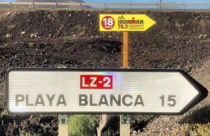 Imagem do pôster IRONMAN 70.3 Lanzarote e a placa de Playa Blanca