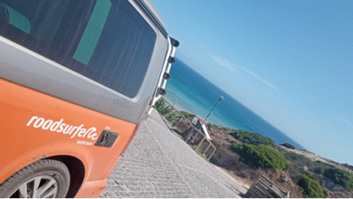 Image of a roadsurfer with a cove in the background in Portugal