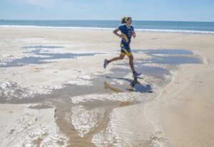 Imagen de una triatleta corriendo en Doñana