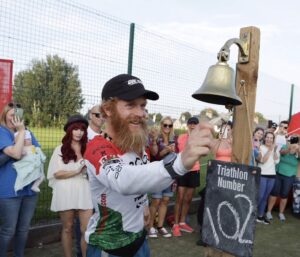 @justinfletcher_photography / Sean Conway tocando la campana en el IRONMAN 102