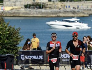IRONMAN/ 2 triathletes running in the IRONMAN Portugal