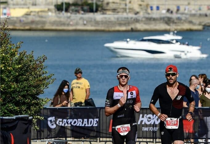 IRONMAN/ 2 triathletes running in the IRONMAN Portugal