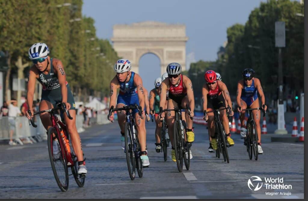WorldTriathlon/ el pelotón con el arco del triunfo de fondo