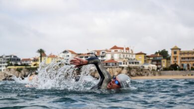 Ein Schwimmer mit Cascais im Hintergrund