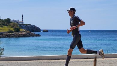 Un triatleta con il faro sullo sfondo nel Tri de Protocolom