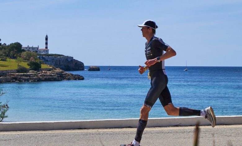 A triathlete with the lighthouse in the background in the Tri de Protocolom