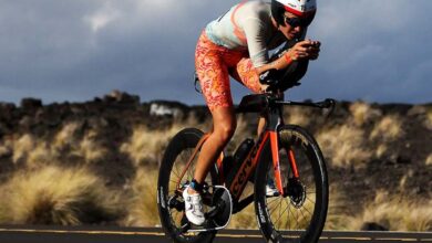 IRONMAN/ image of a triathlete in Kona cycling
