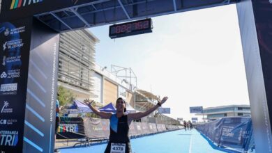 A triathlete celebrating at the finish line of an MTRI