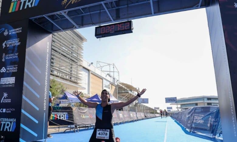 A triathlete celebrating at the finish line of an MTRI