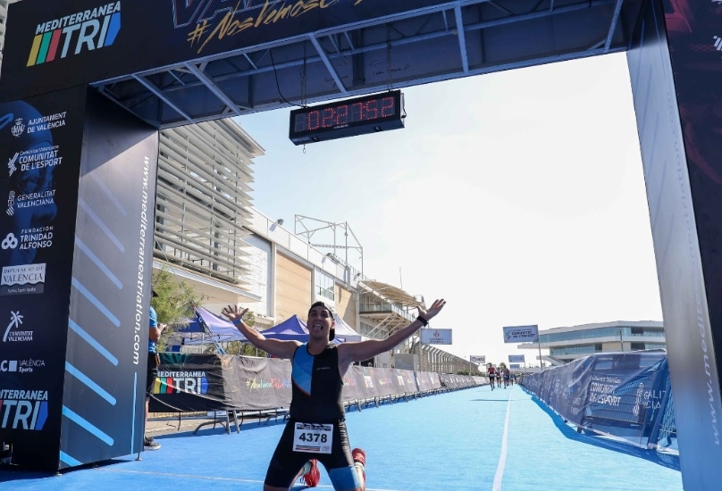 A triathlete celebrating at the finish line of an MTRI