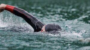 Canva/ um triatleta nadando em águas abertas