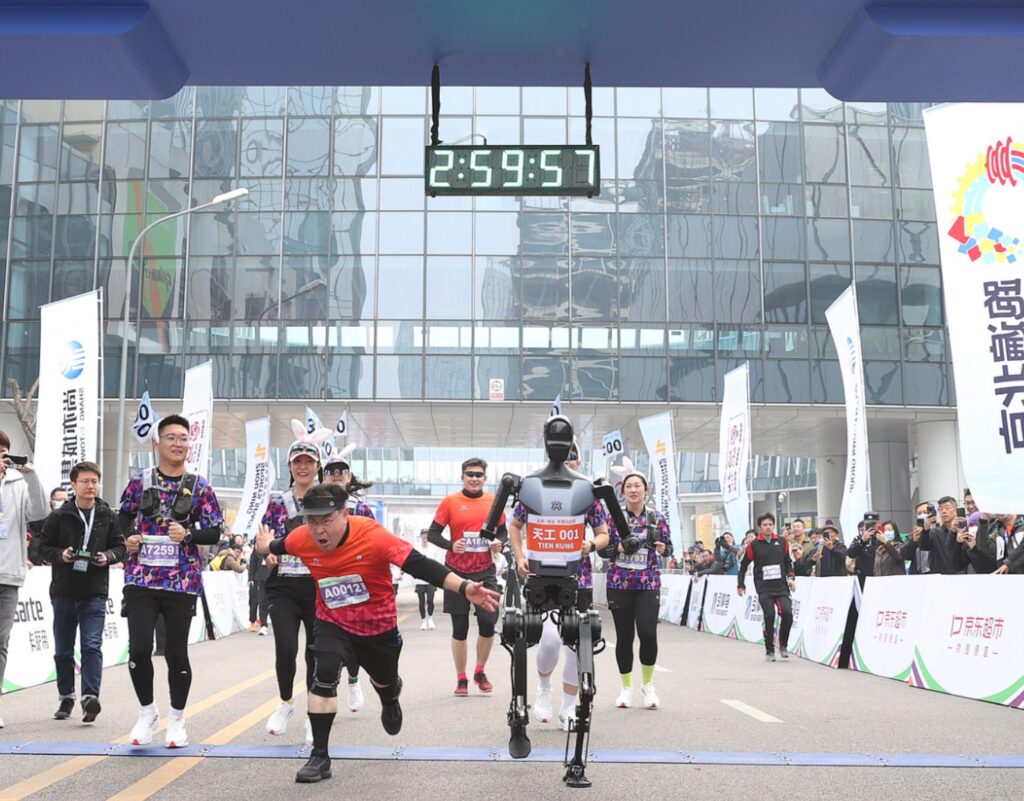 cgtn/Imagen de un humano y un robot entrando en meta