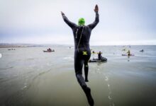 @escapealcatraztri/ Un triatleta saltando desde el barco en el Escape From Alcatraz Triathlon