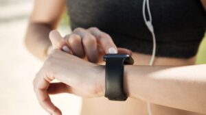 canva/ Una runner configurando su reloj GPS