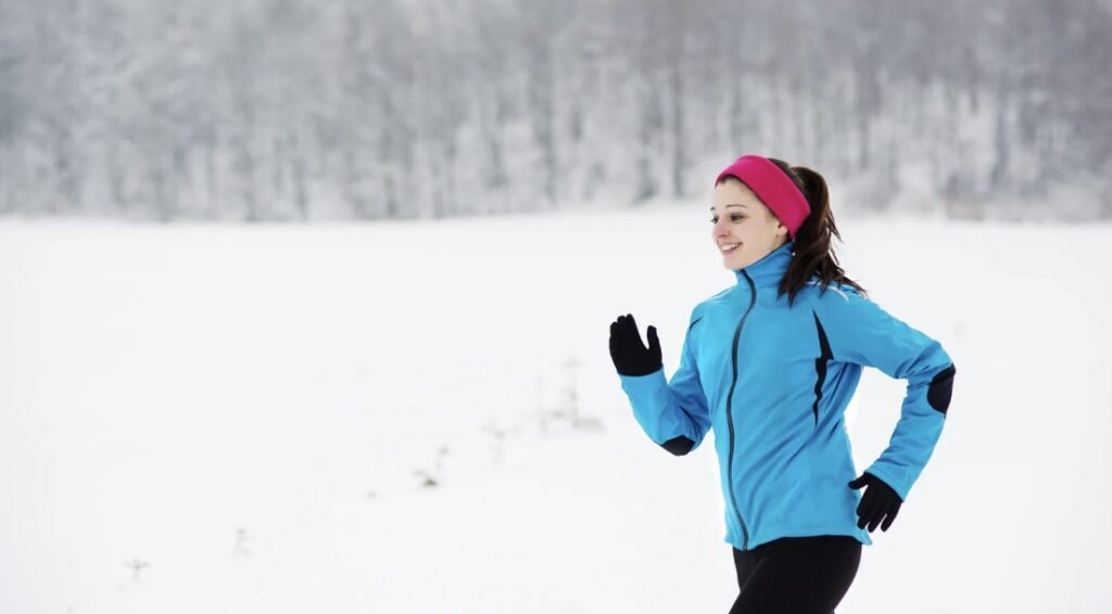 canva/ Imagen de una mujer corriendo con frio y nieve