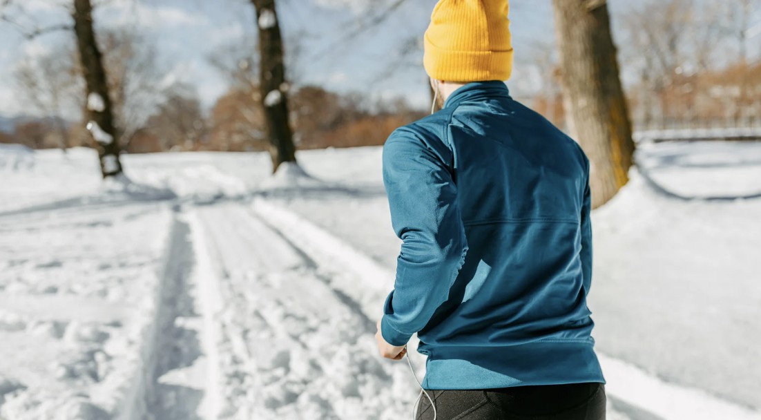 canva/ Un corredor entrenando en invierno