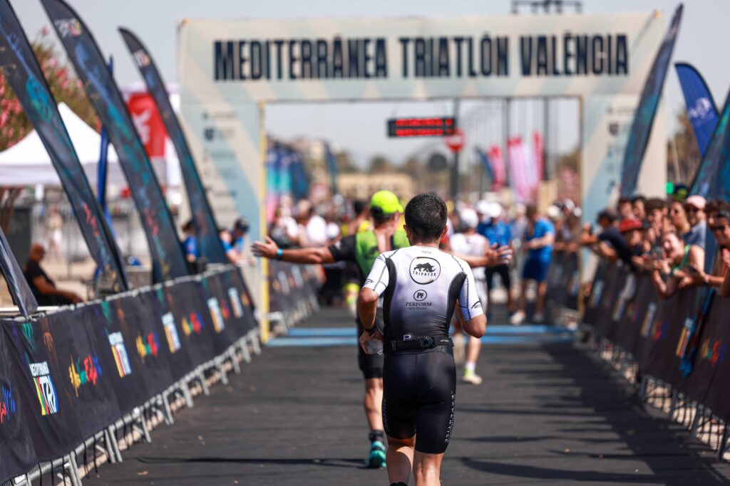 Triatleta cruzando la meta del Mediterránea Triatlón València ante el público