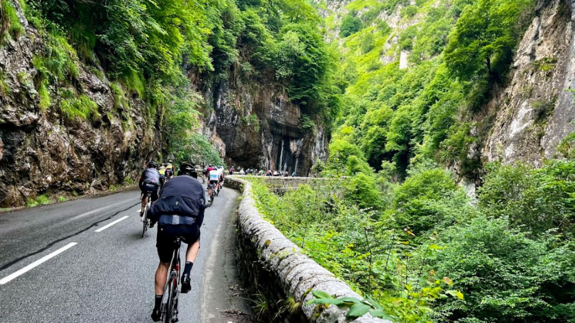 Ciclistas entrenando en una carretera de montaña en España, en un entorno natural habitual para rutas de ciclismo de carretera.