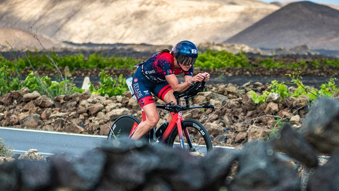 Triatleta compitiendo en el segmento ciclista del IRONMAN Lanzarote sobre paisaje volcánico