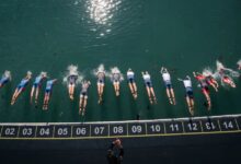 Salida de natación con triatletas profesionales lanzándose al agua en una prueba Supertri Título de la imagen Inicio del segmento de natación en una carrera Supertri