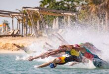 Salida masculina de la WTCS con triatletas lanzándose al agua en una playa