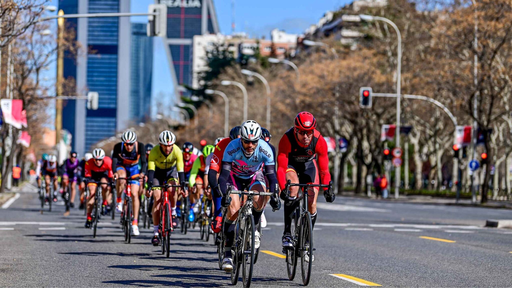 Duatletas compitiendo en bicicleta en el Duatlón Villa de Madrid por el Paseo de la Castellana