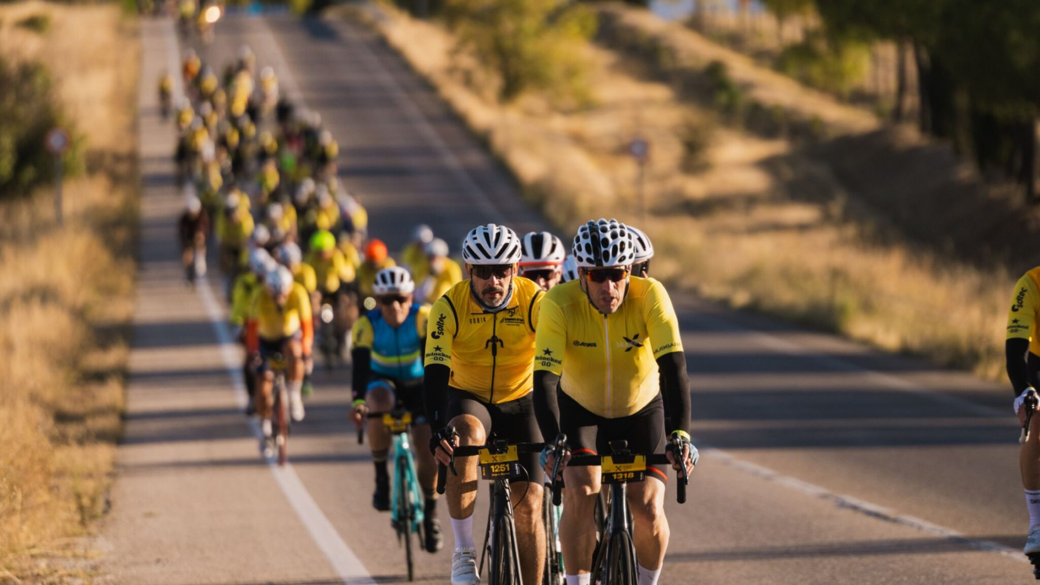Pelotón de ciclistas participando en una marcha cicloturista tipo Mussara en carretera abierta