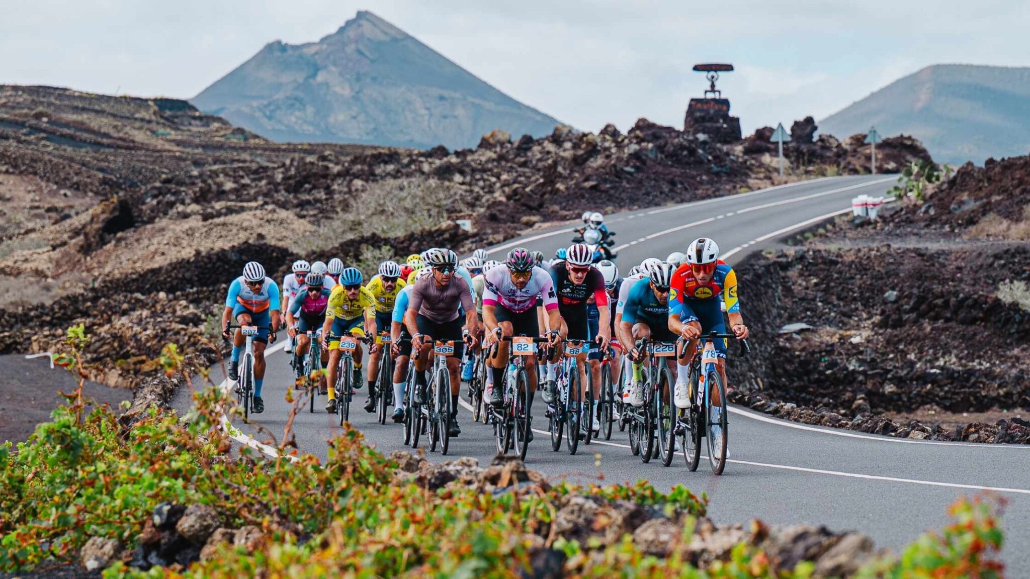 Ciclistas rodando en la Vuelta Ciclista a Lanzarote entre paisajes volcánicos