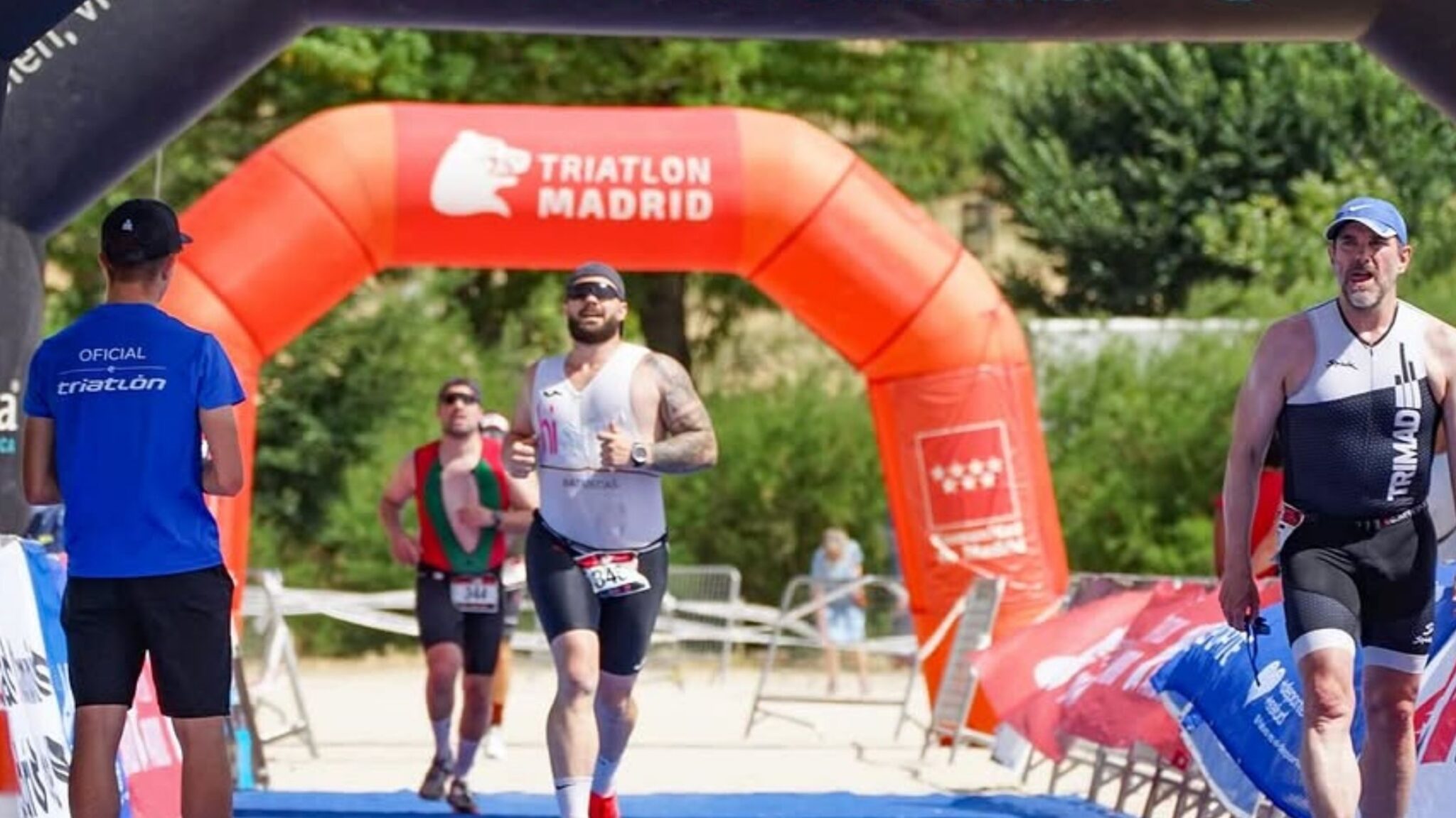 Triatletas populares entrando en meta en el Gran Triatlón Madrid en la Casa de Campo