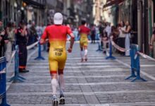 Dos triatletas españoles corren por una calle del centro de Pamplona durante un segmento urbano