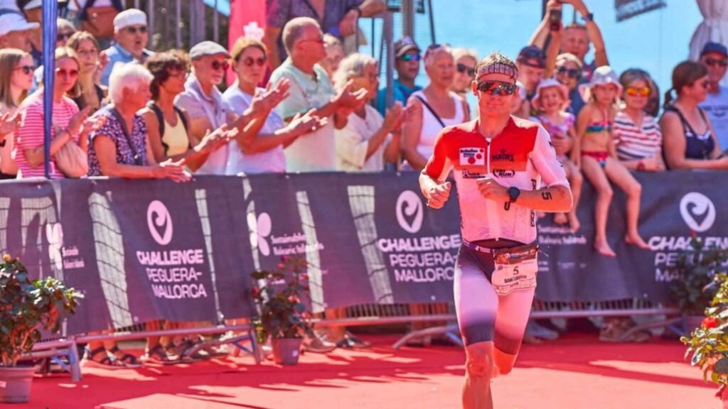 Triatleta corriendo junto al público en Challenge Peguera Mallorca