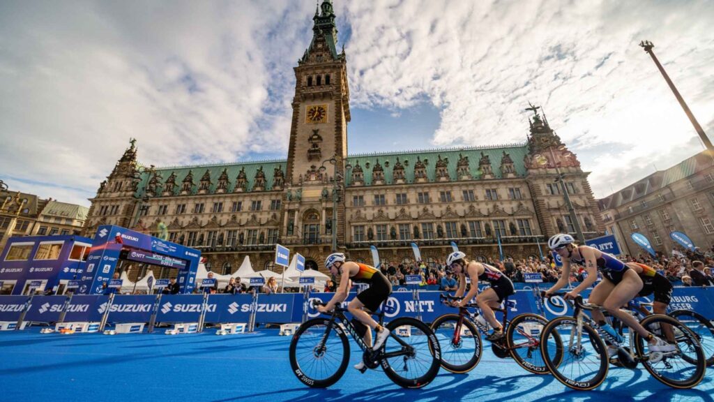Triatletas en bicicleta compitiendo frente al Ayuntamiento de Hamburgo
