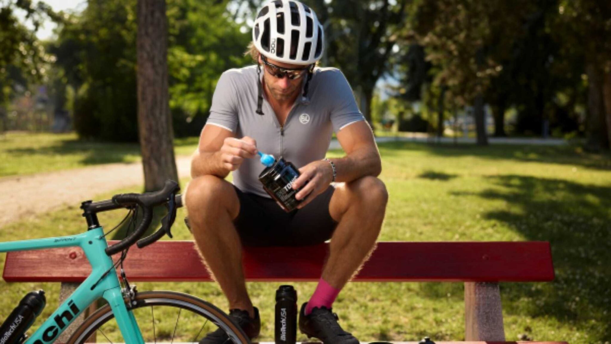 IsoTonic: la bebida isotónica de BioTechUSA para rendir más en tus entrenos de triatlón - Nutrición deportiva en deportes de resistencia Deportista preparando IsoTonic de BioTechUSA en un bidón de entrenamiento