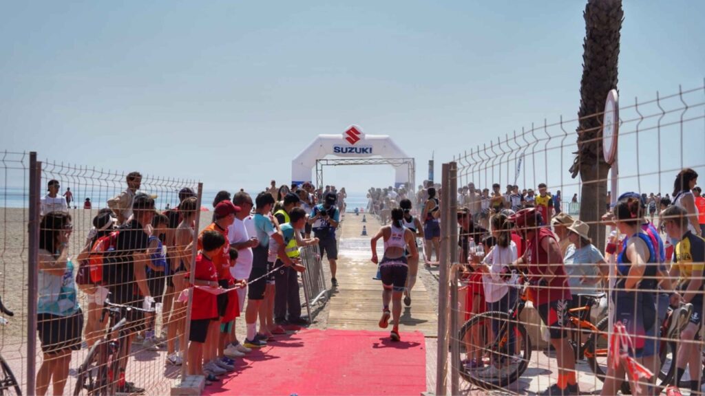 Triatletas compitiendo en los relevos de Roquetas de Mar junto a la playa