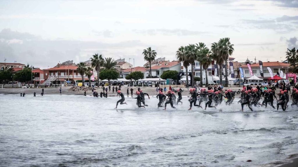 Salida de la natación en triXilxes con triatletas entrando al mar en la playa de Xilxes