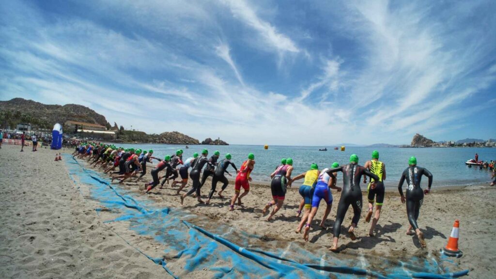 Salida de triatletas en la playa durante una competición de triatlón en Águilas