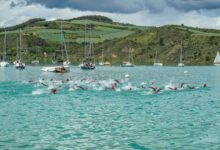 Triatletas nadando en el embalse de Alloz durante una prueba de triatlón en Navarra