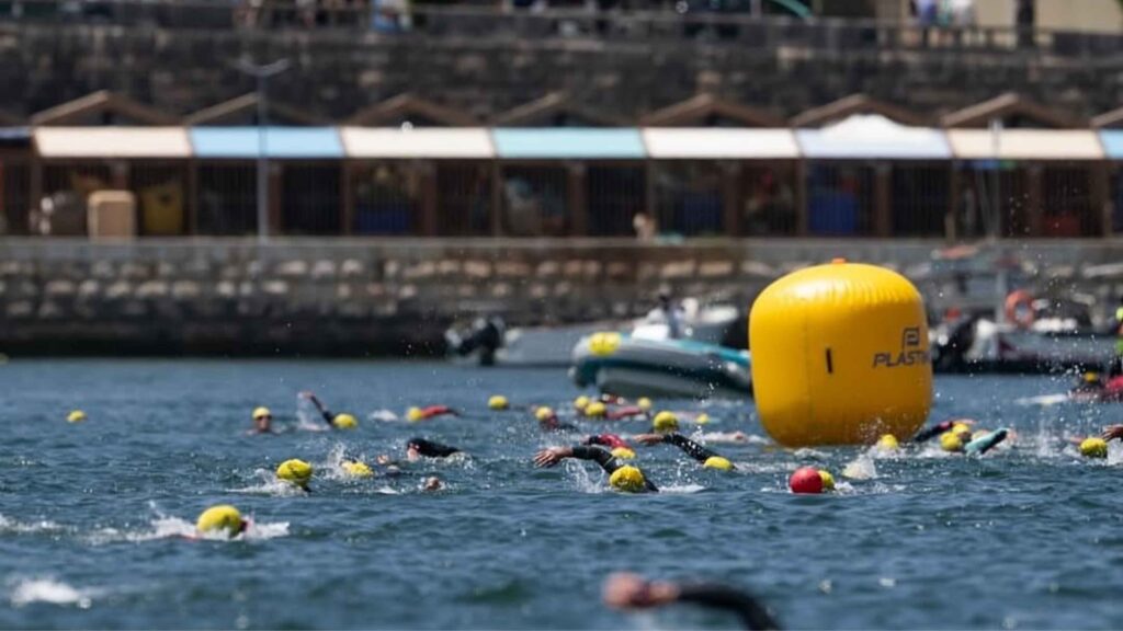 Nadadores en una travesía de aguas abiertas junto a una boya de orientación
